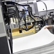 Worker Preparing Large White Papers for Print at the Printing Machine